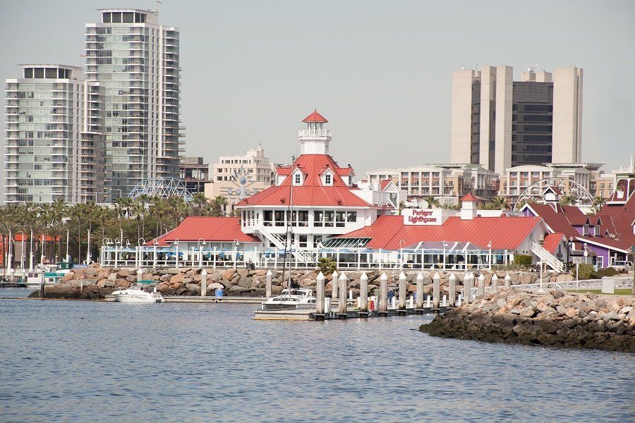 A large building with a red roof is in the middle of a body of water.