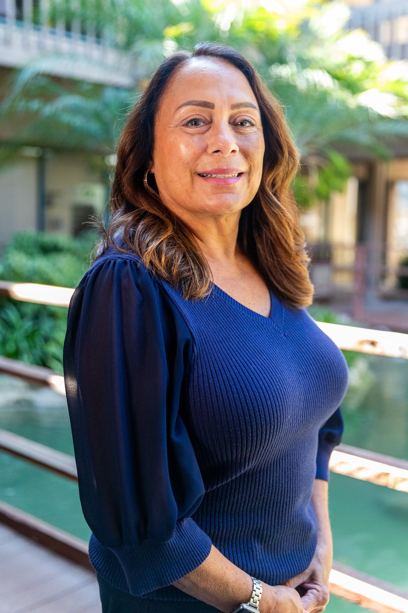 A woman in a blue dress is smiling for the camera.