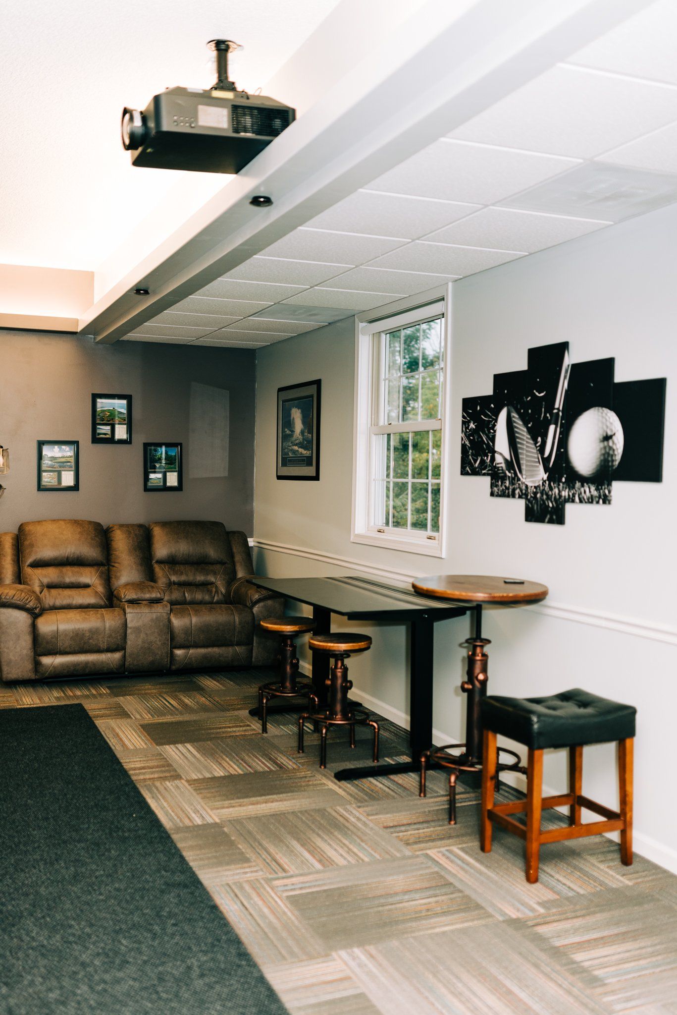 A living room with a projector hanging from the ceiling