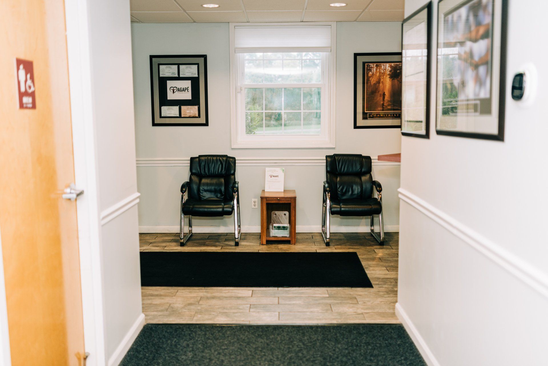 A hallway with two chairs in it and a window.