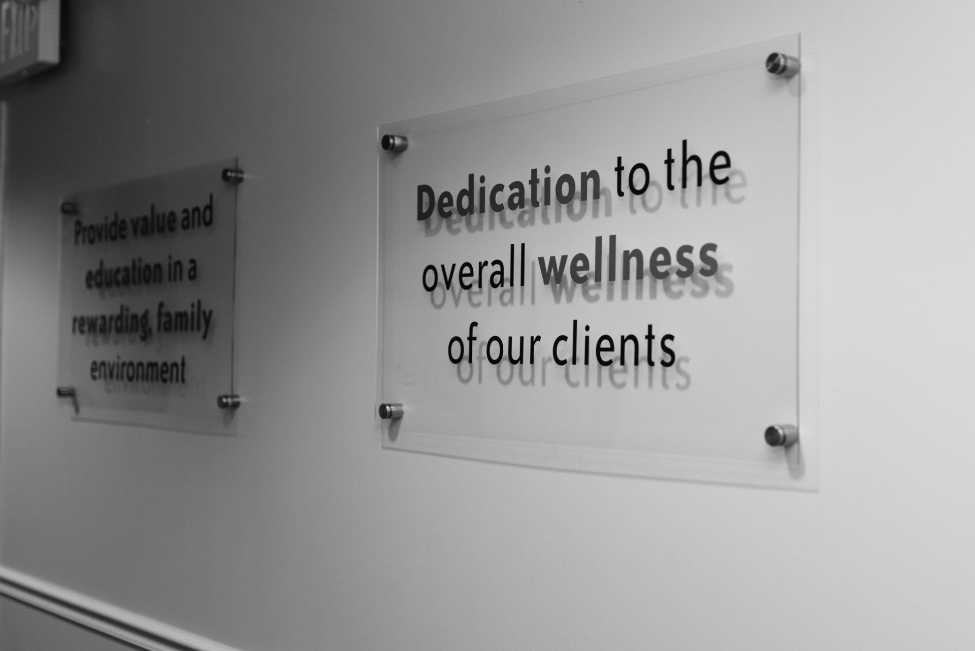 A sign on a wall that says dedication to the overall wellness of our clients