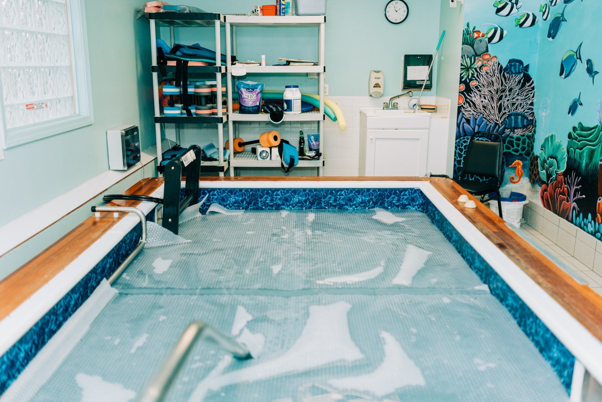 A small swimming pool in a room with a calendar on the wall