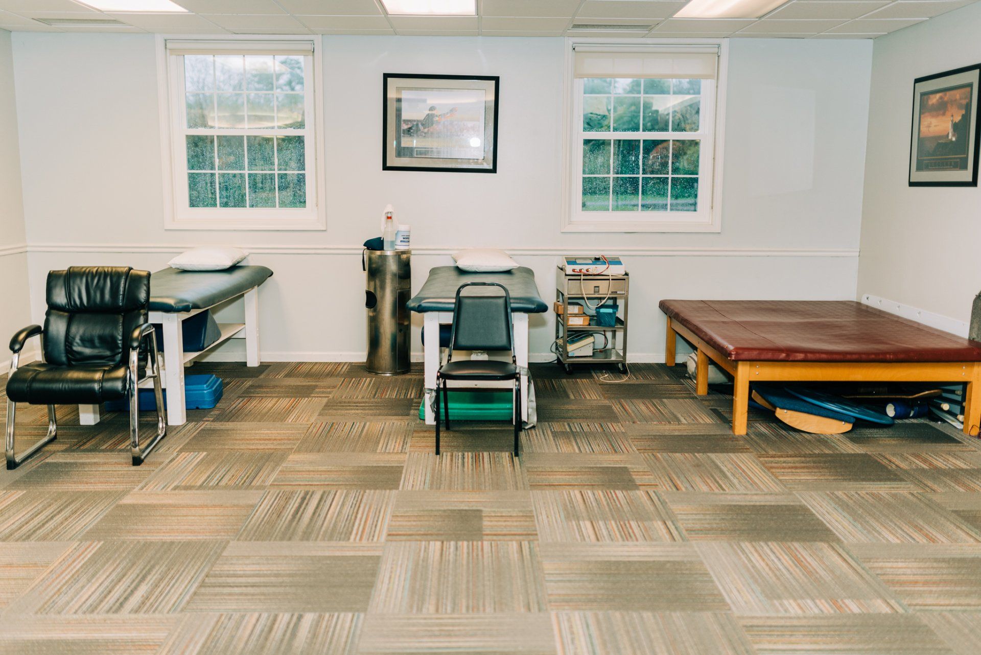 There are two tables and a chair in the room.