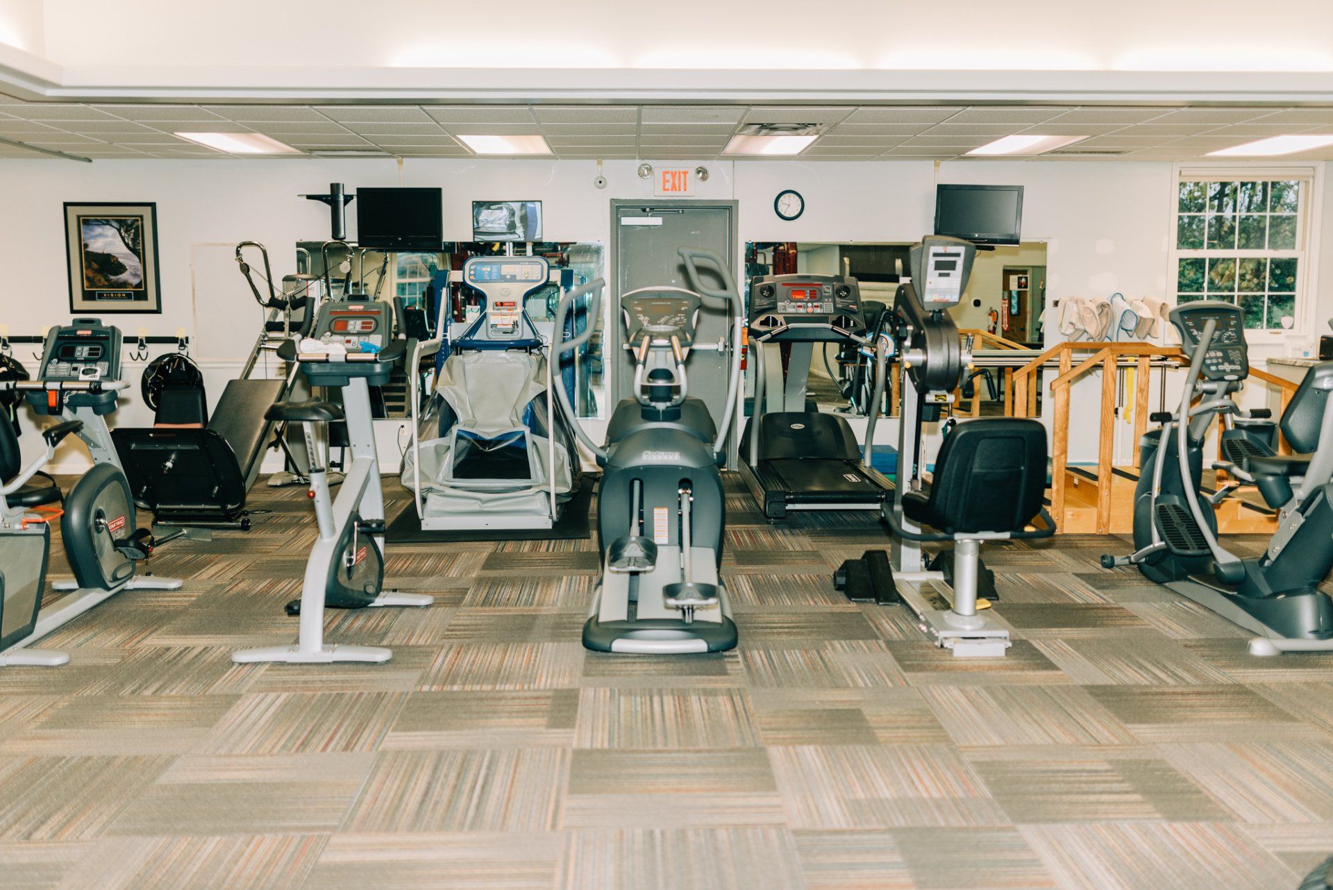 A large gym filled with lots of exercise equipment.
