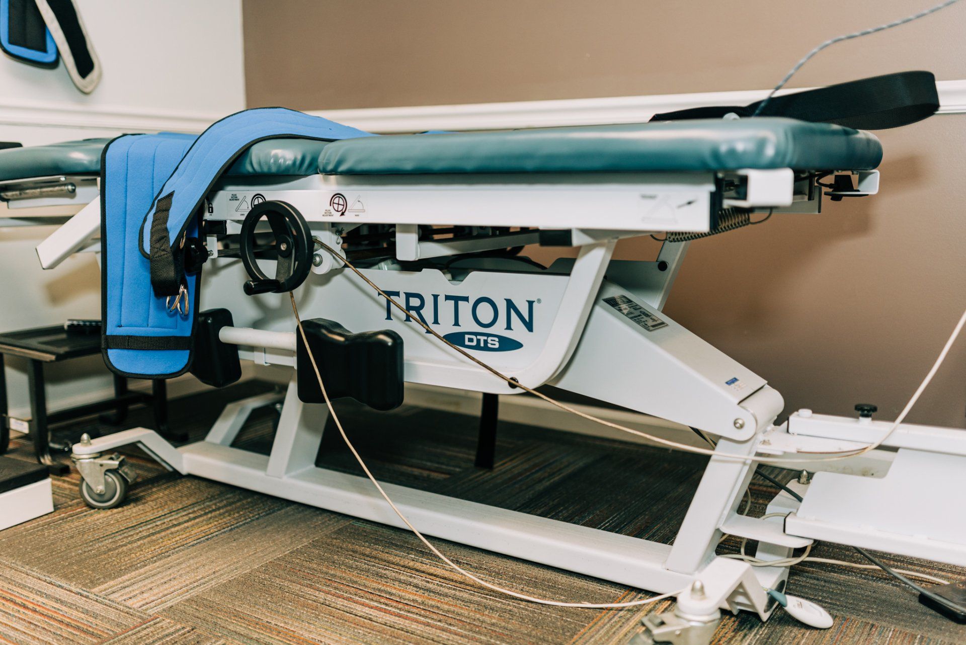 A triton chiropractic table is sitting on the floor in a room.