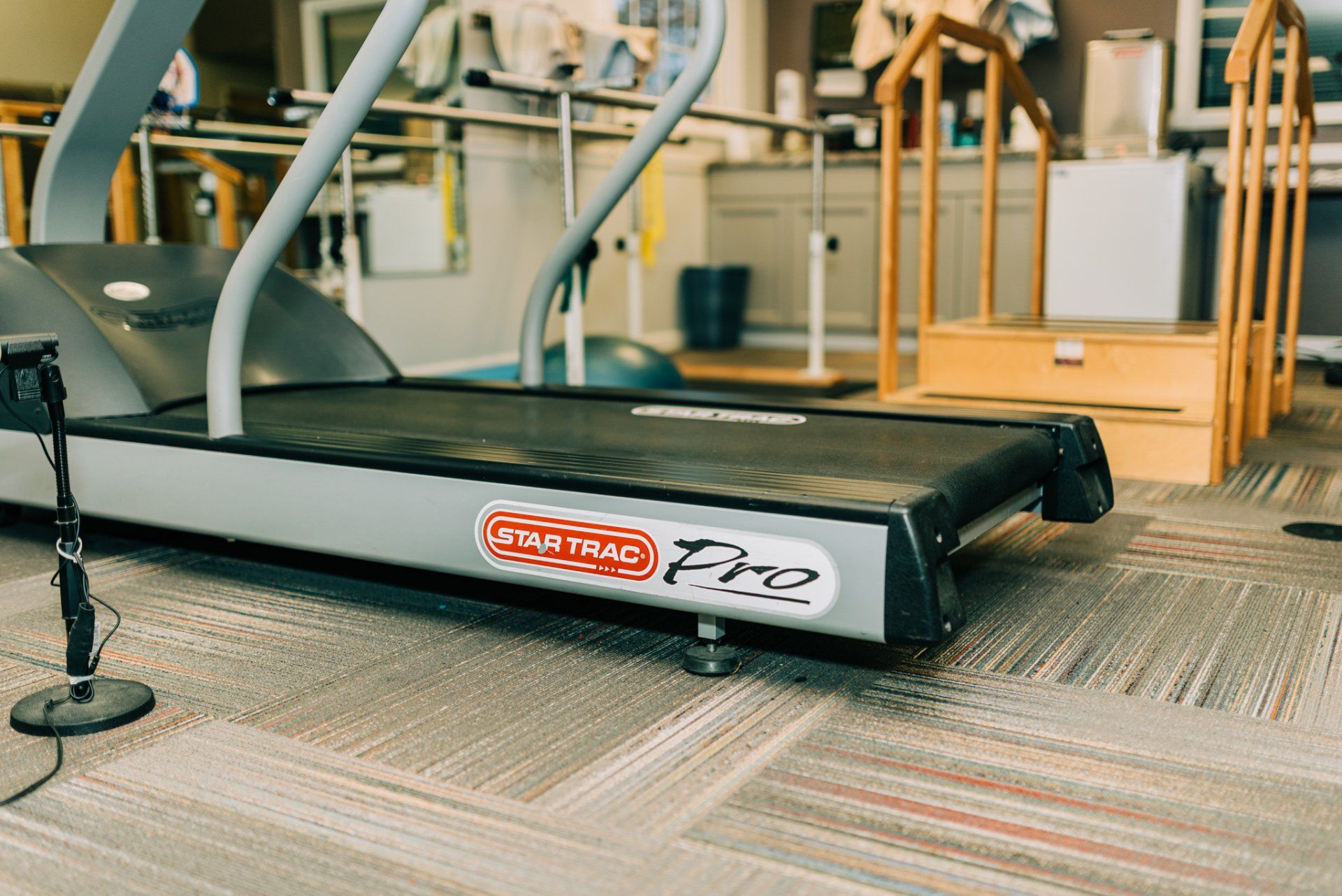 A treadmill is sitting on the floor in a gym.