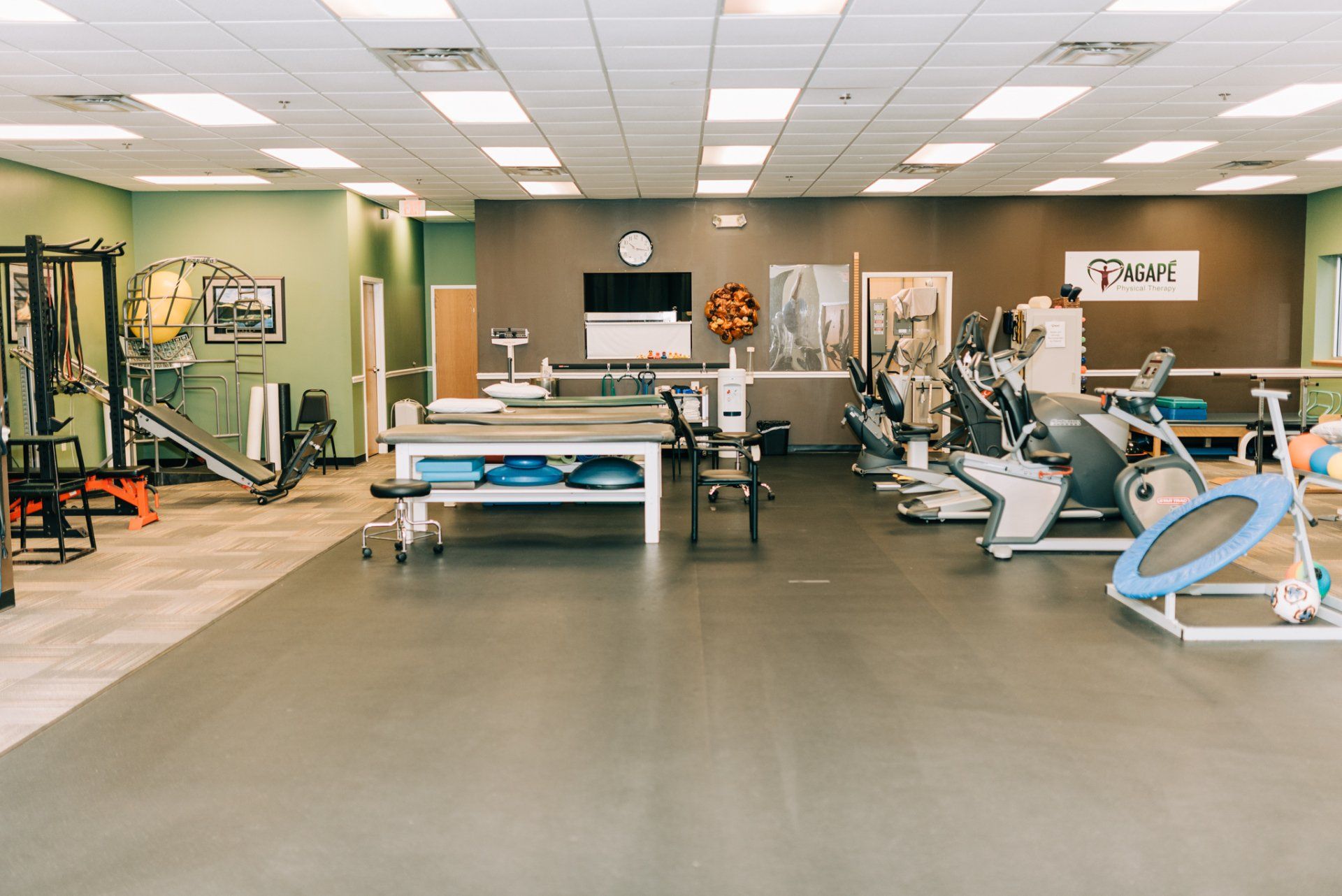 A large gym filled with lots of exercise equipment and tables.