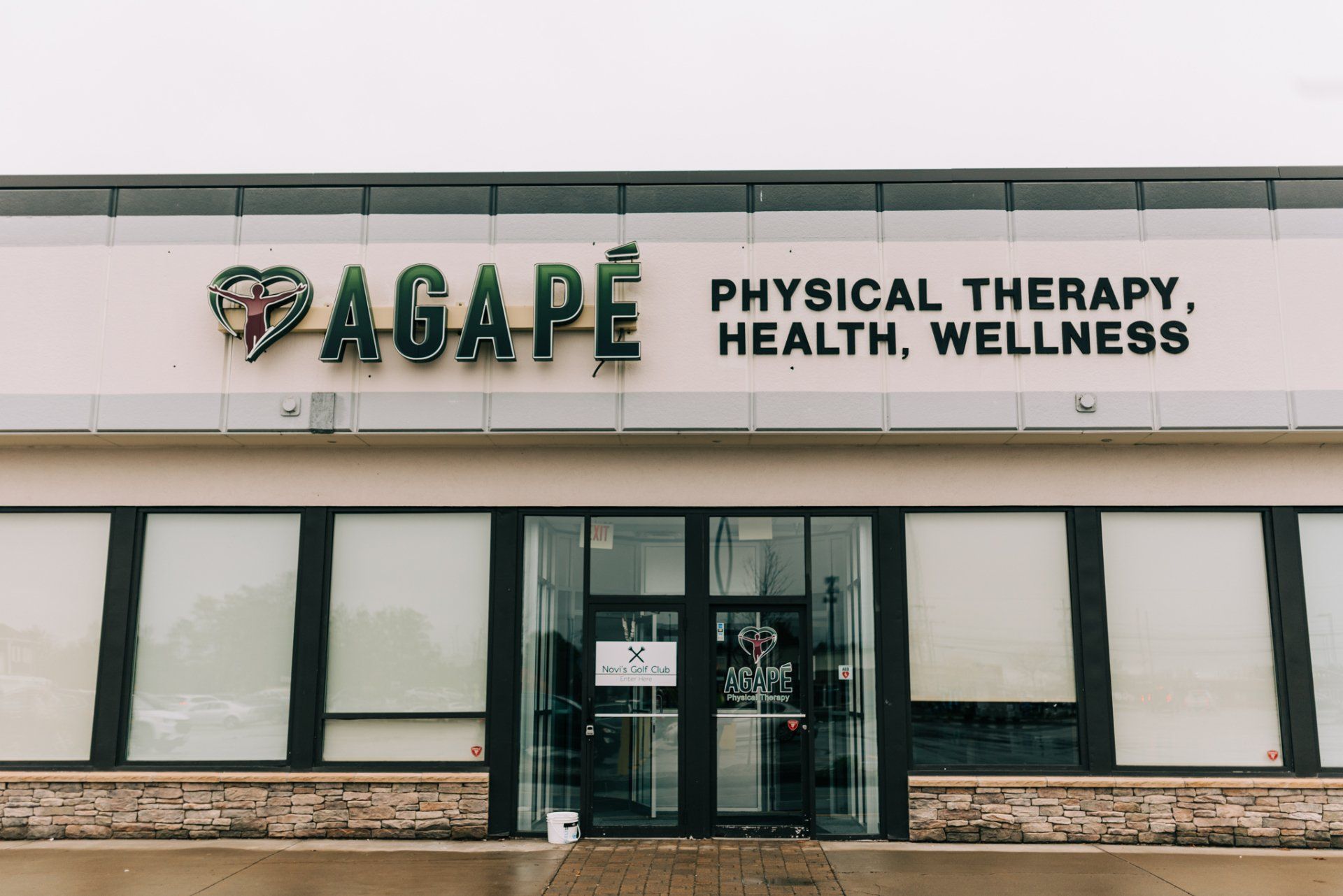 A large building with a sign that says physical therapy , health , wellness.