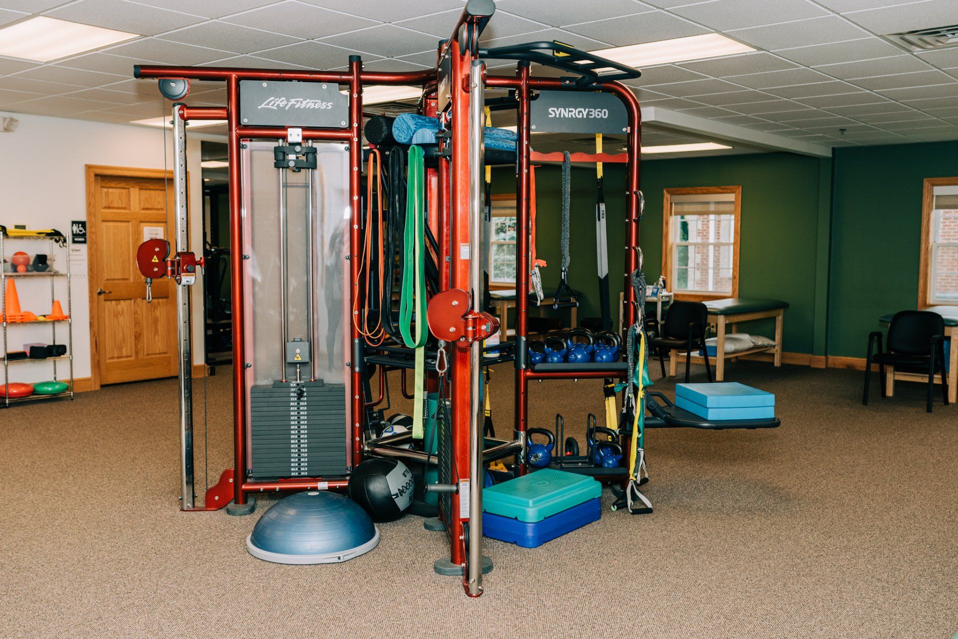 A gym with a lot of exercise equipment in it.