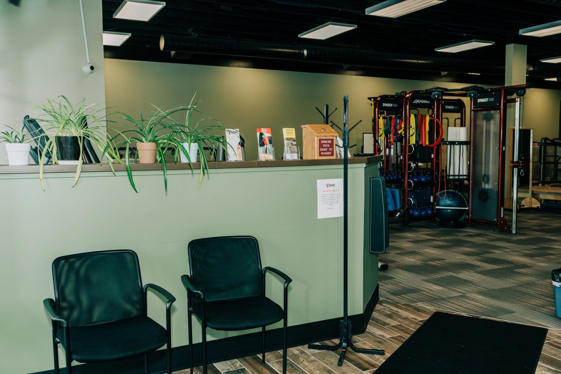 There are three chairs in the waiting room of a gym.