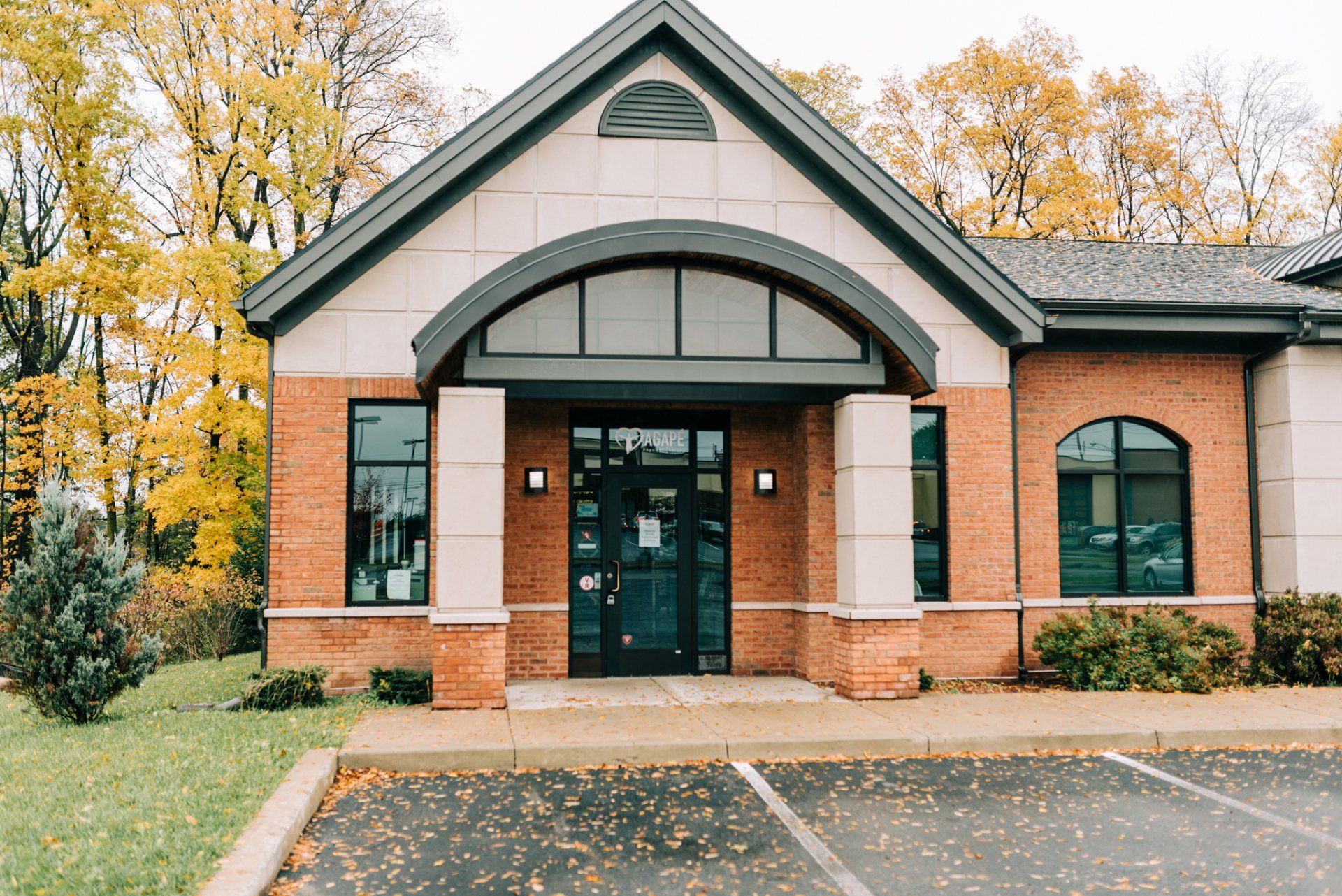 A large brick building with a parking lot in front of it.