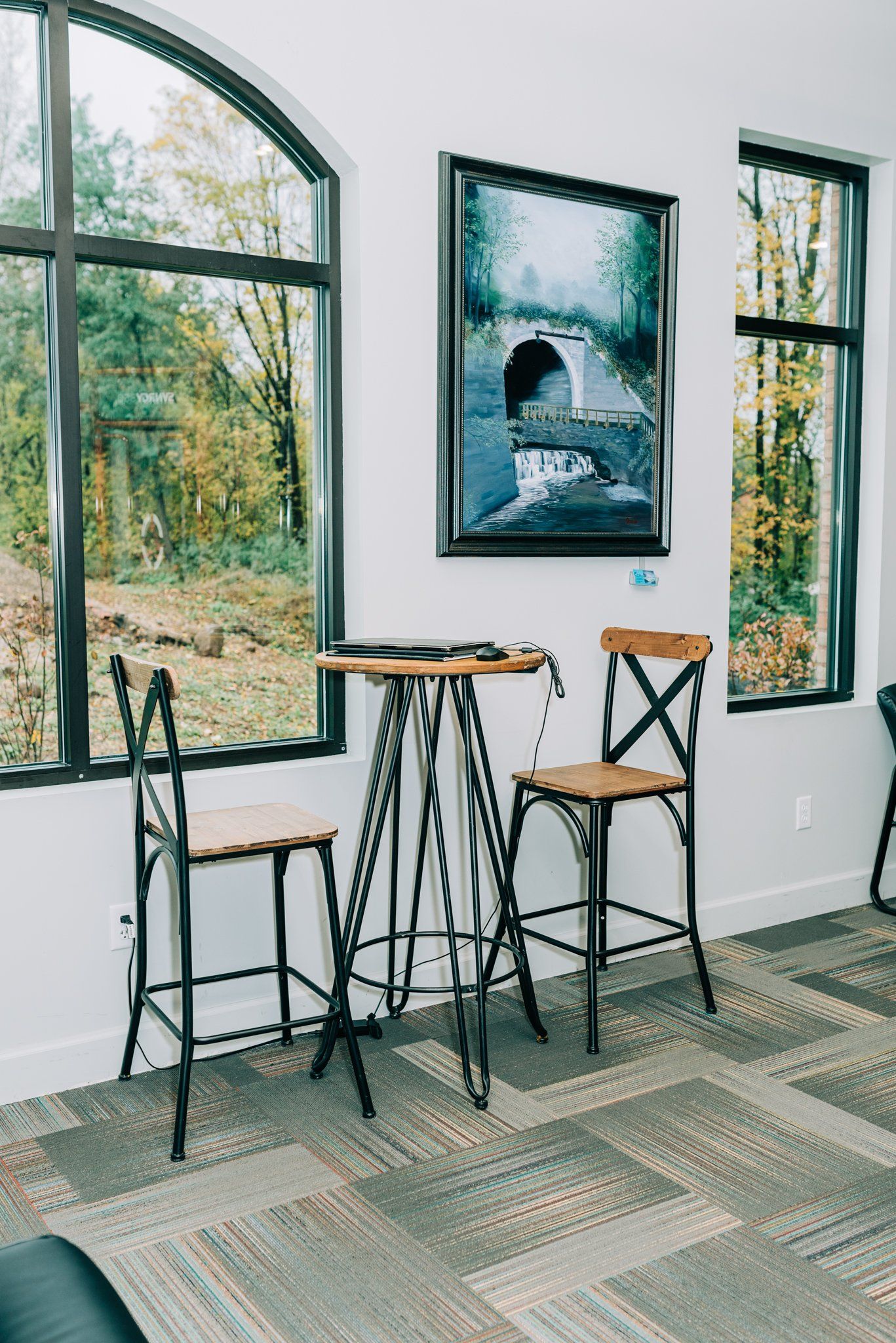 A room with a table and chairs and a painting on the wall