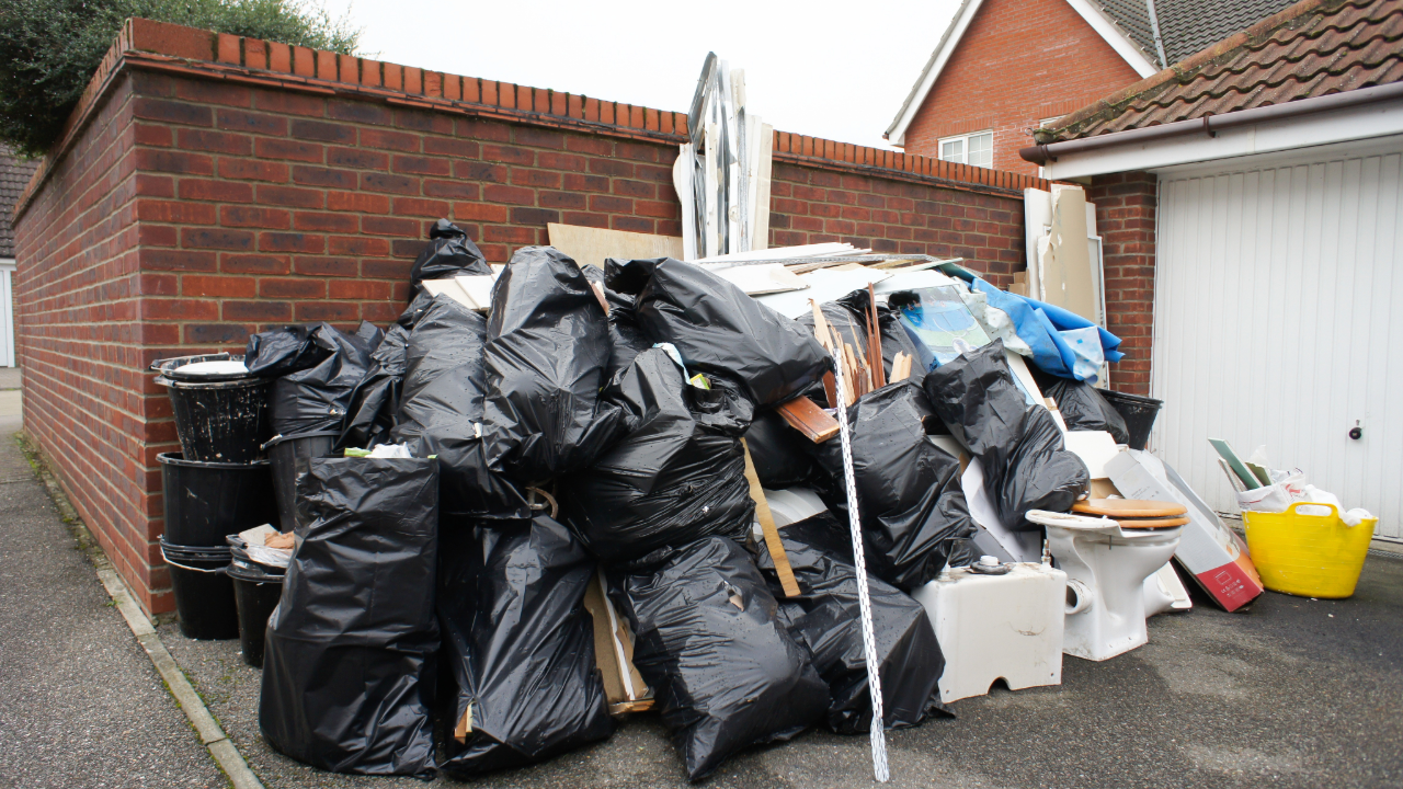 A pile of garbage bags is sitting on the side of the road.