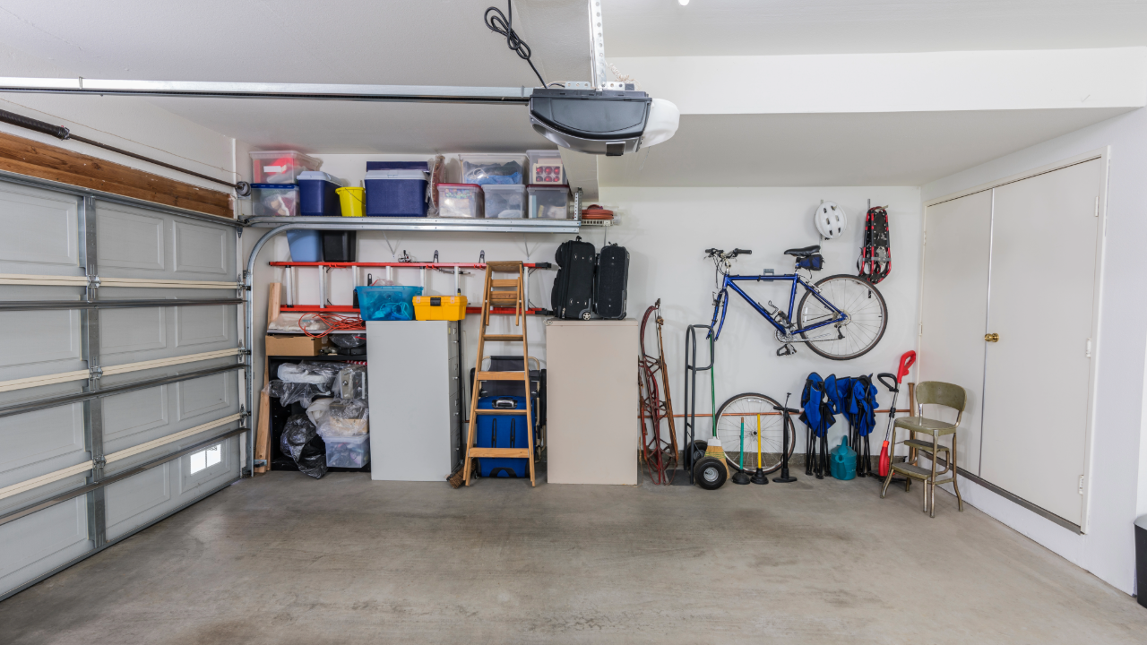 An empty garage with a bicycle hanging on the wall.