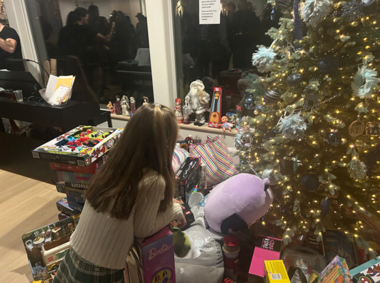 Girl looking at presents under a Christmas tree