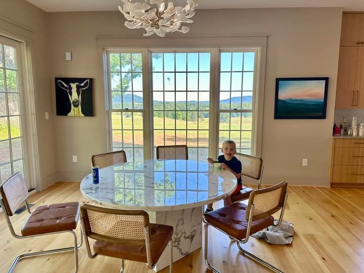 A little boy is sitting at a table in a dining room.