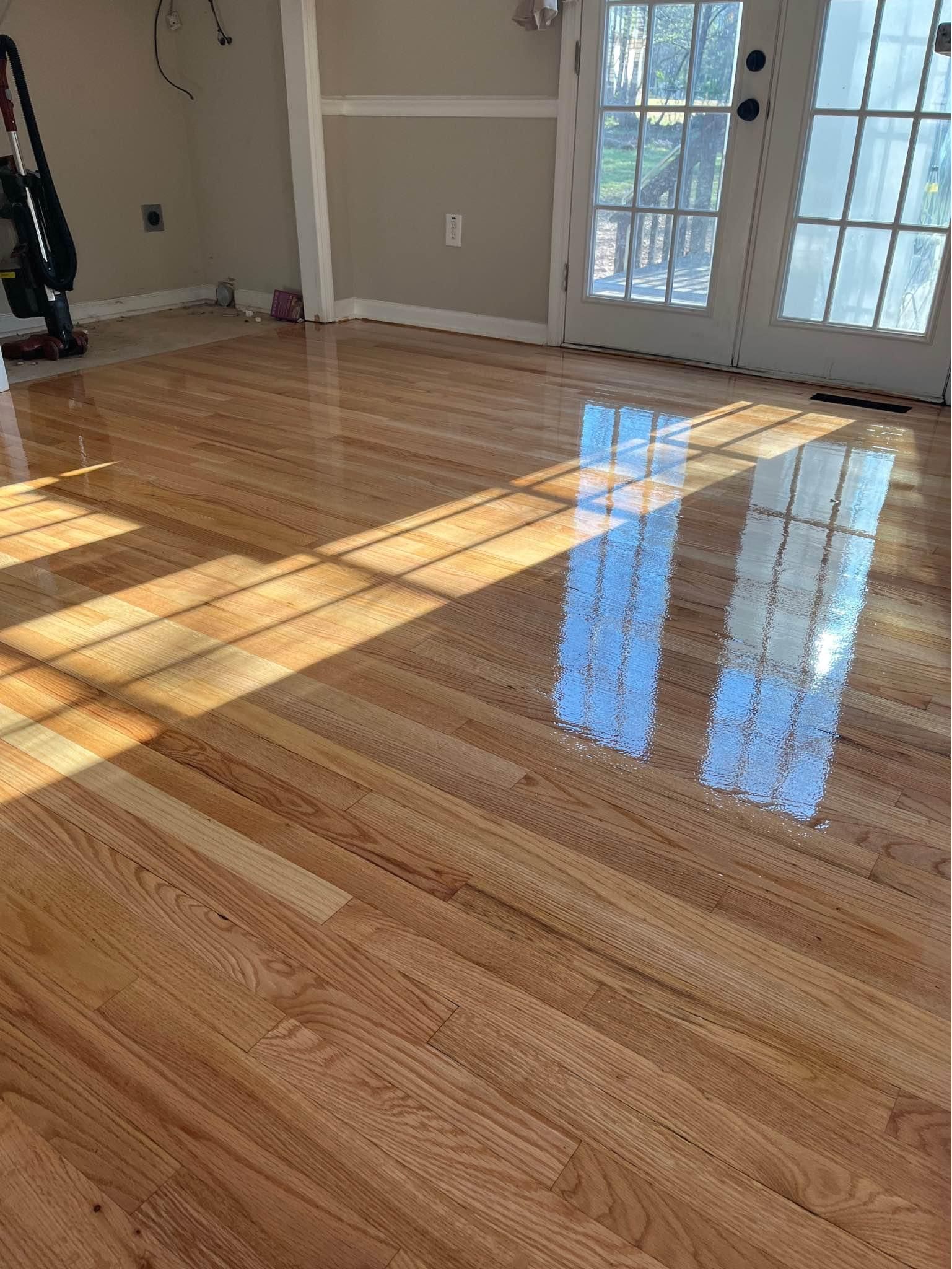 A close up of a shiny wooden floor in a room.
