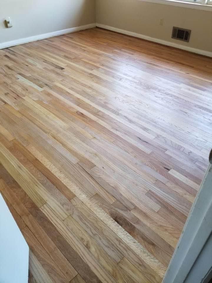A room with a wooden floor and a window.