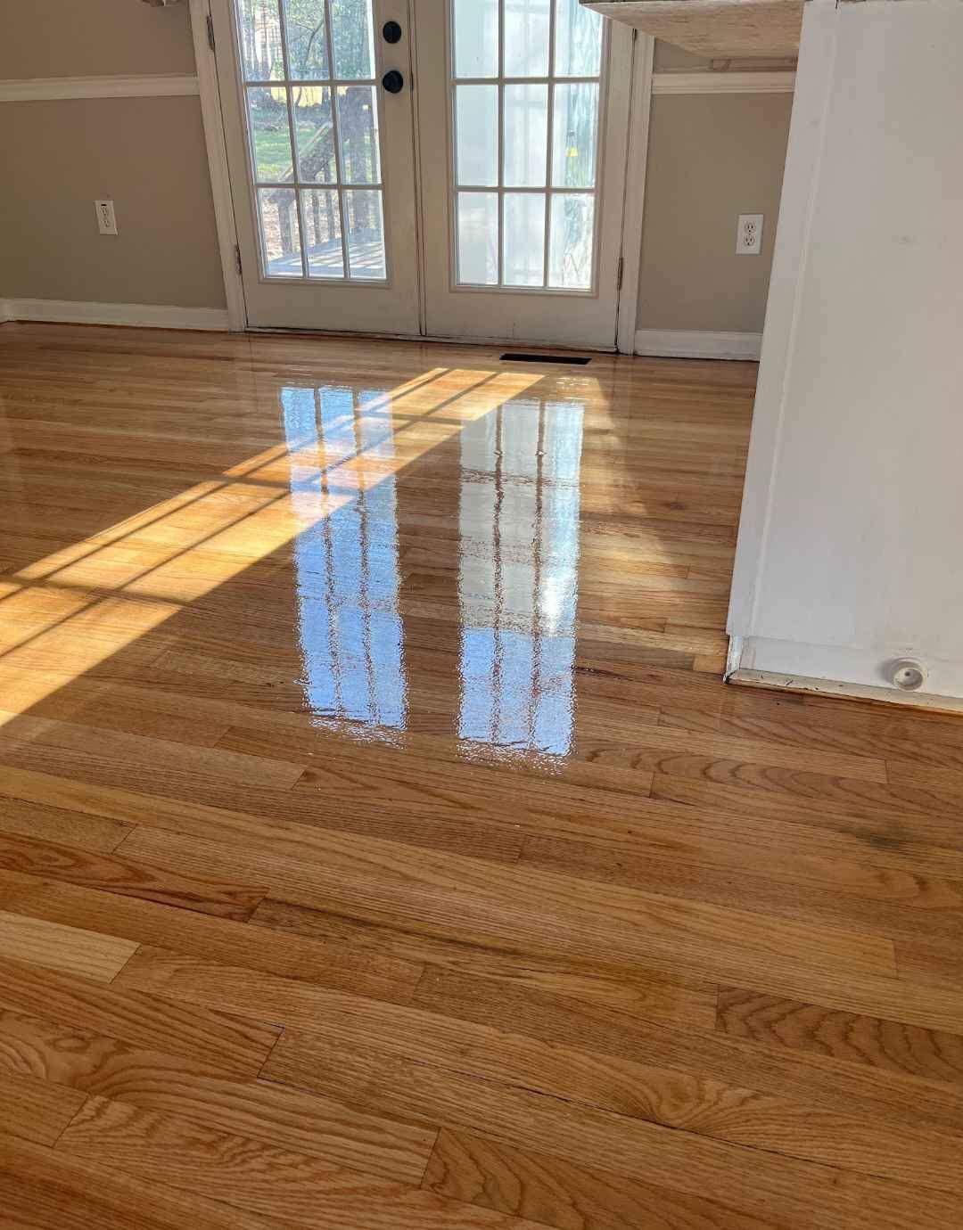 A room with a wooden floor and a sliding glass door.