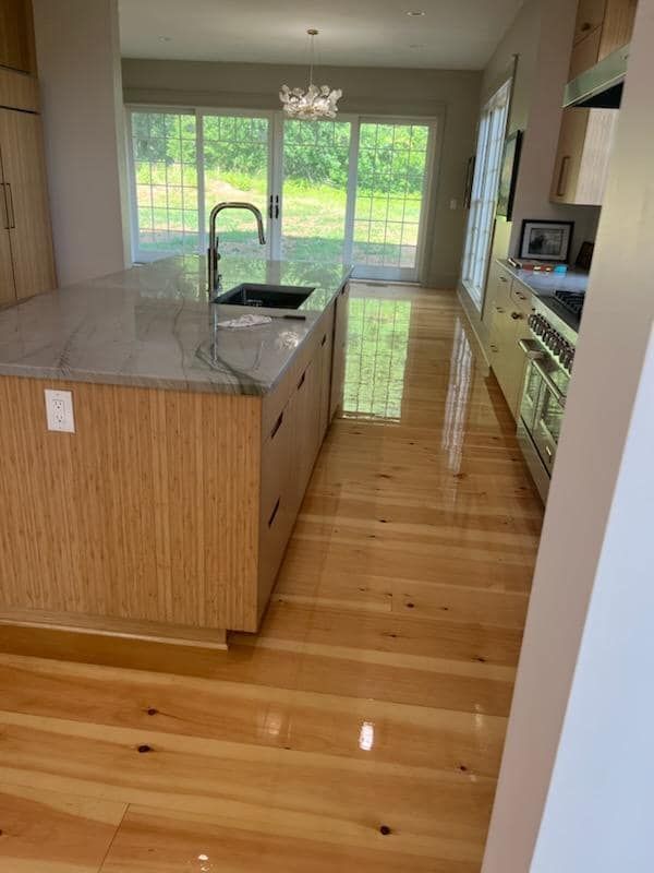 A person is cleaning a wooden floor with a cloth.