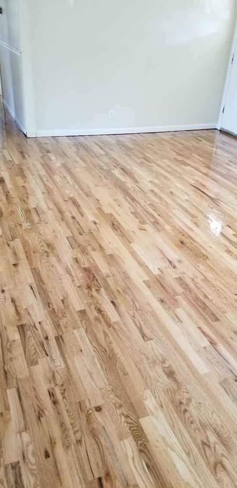 A living room with a wooden floor and a white wall.