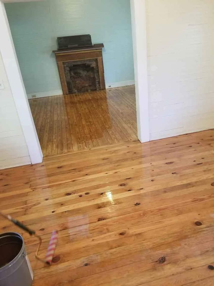 A wooden floor in a room with a fireplace.