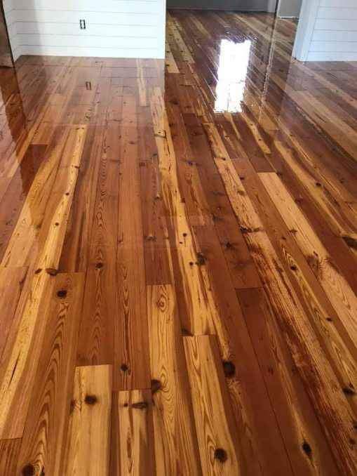 A person is installing a wooden floor with a hammer.
