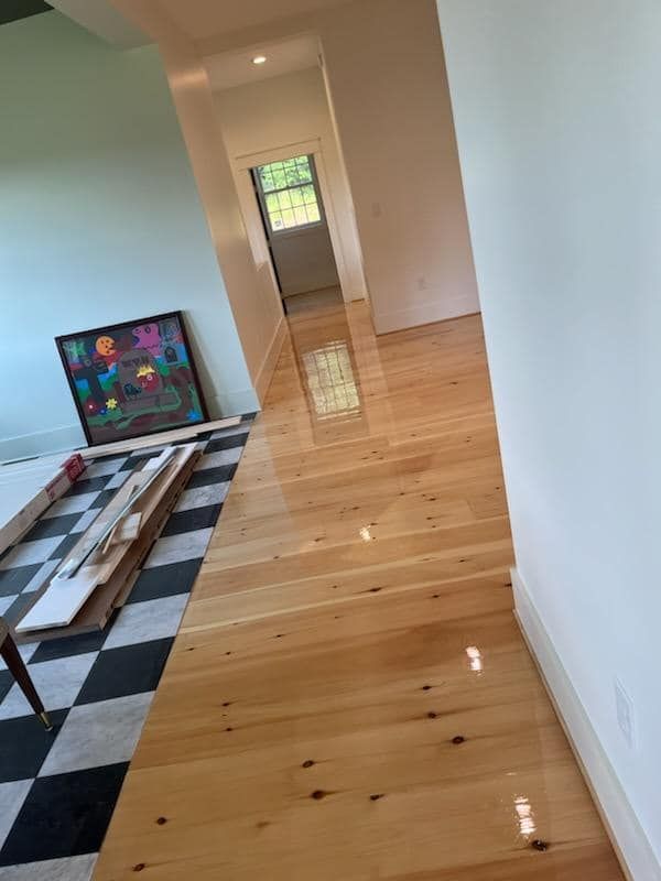 A hallway with wooden floors and a checkered floor.