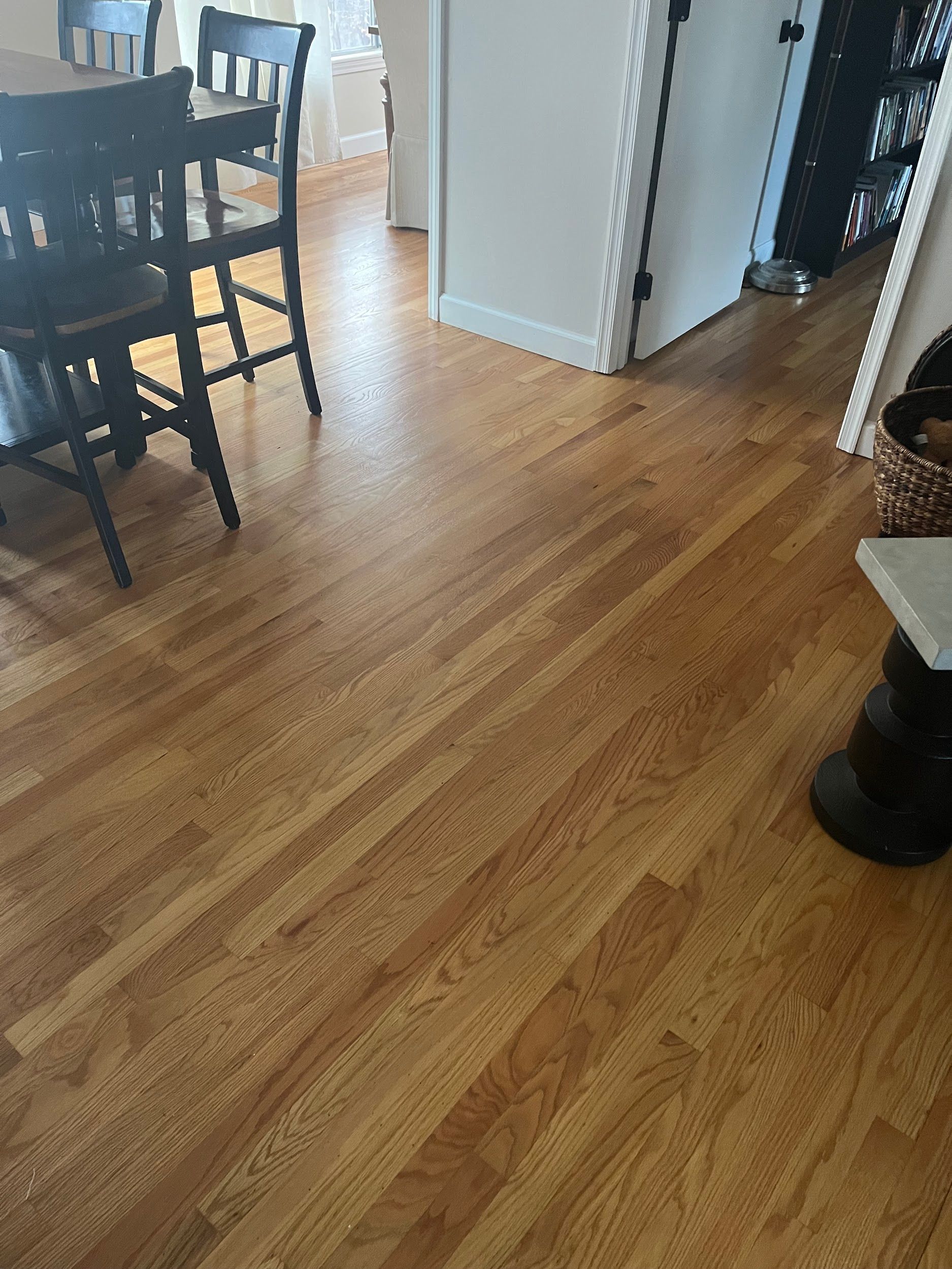 A wooden floor in a dining room with a table and chairs.
