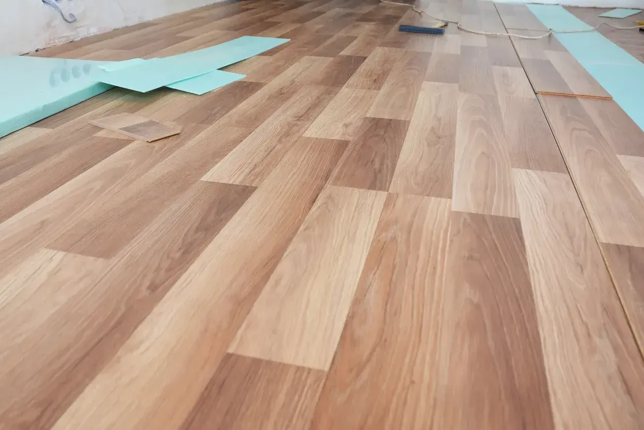 A wooden floor with a staircase in the background