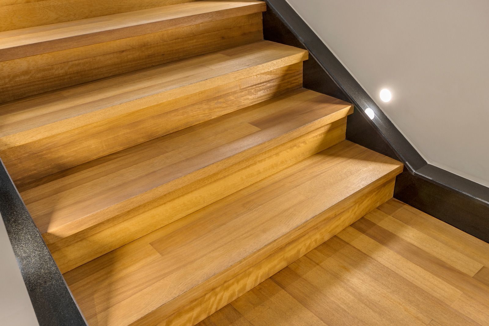 A close up of a wooden staircase with a metal railing.