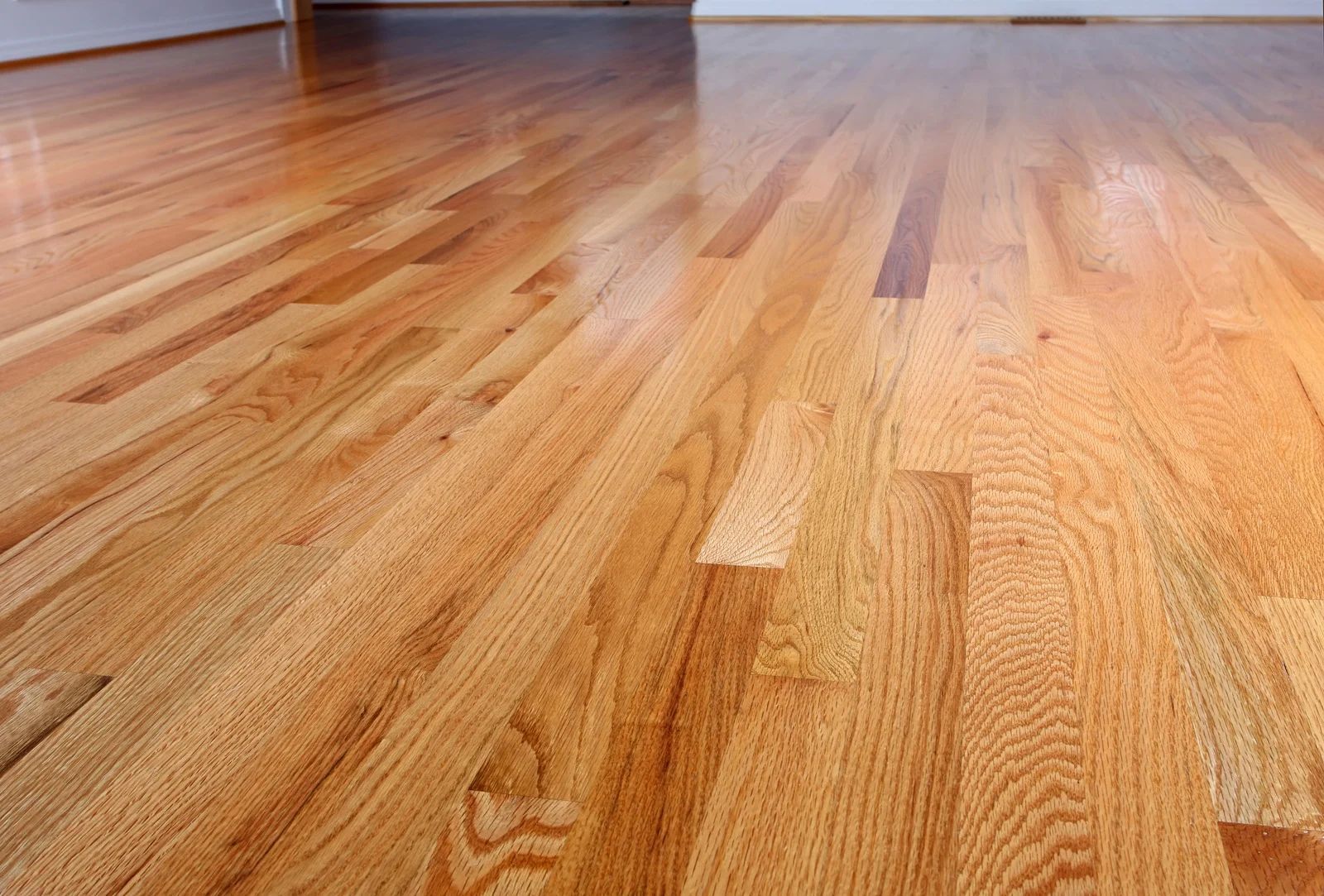 Wood floor, light brown color, with a shiny finish.