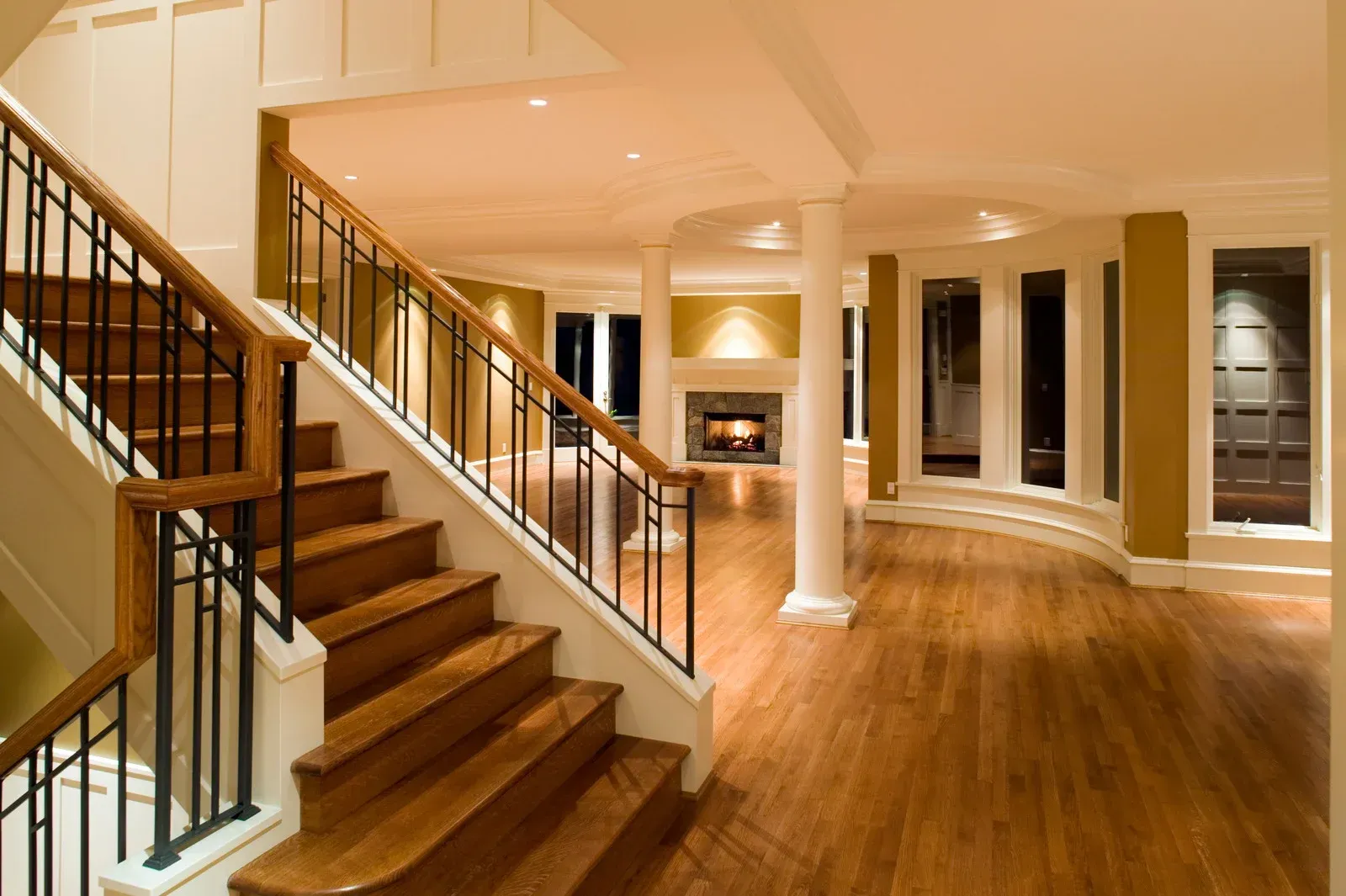 A wooden staircase with a metal railing in an empty room