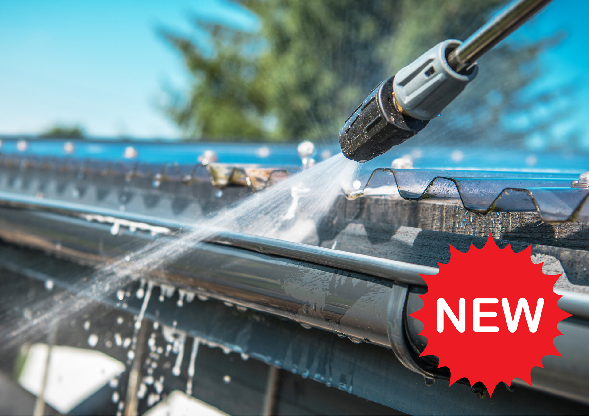 Power washing a dark gutter on a rooftop, water spraying with 
