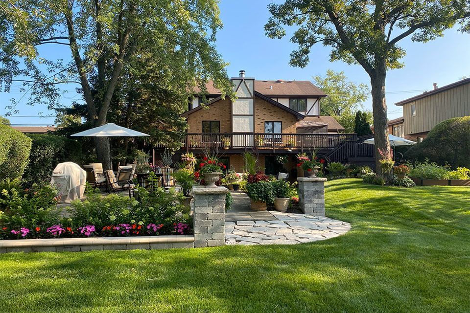 Finished landscape design with structured planting, stone walkways, and outdoor living areas for a residential backyard.