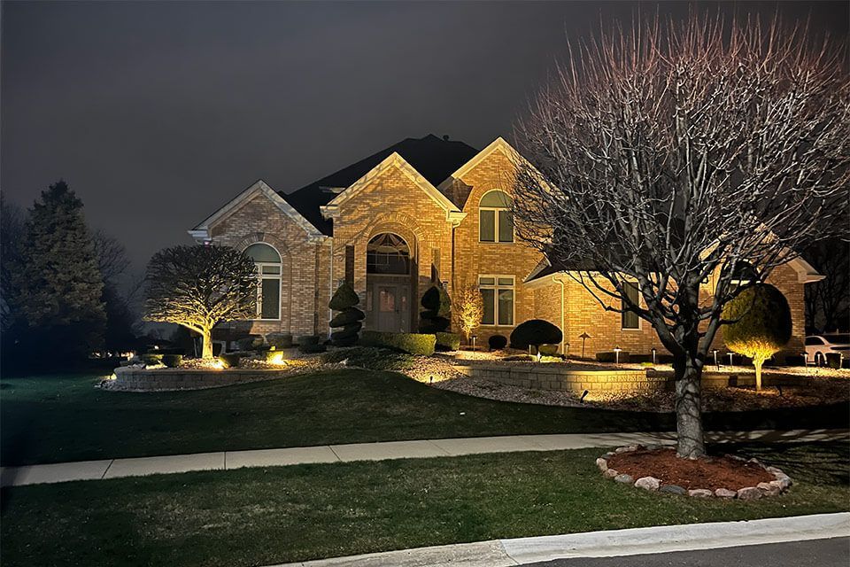 Professional landscape lighting illuminating walkways and architectural features to enhance nighttime curb appeal for a residential home
