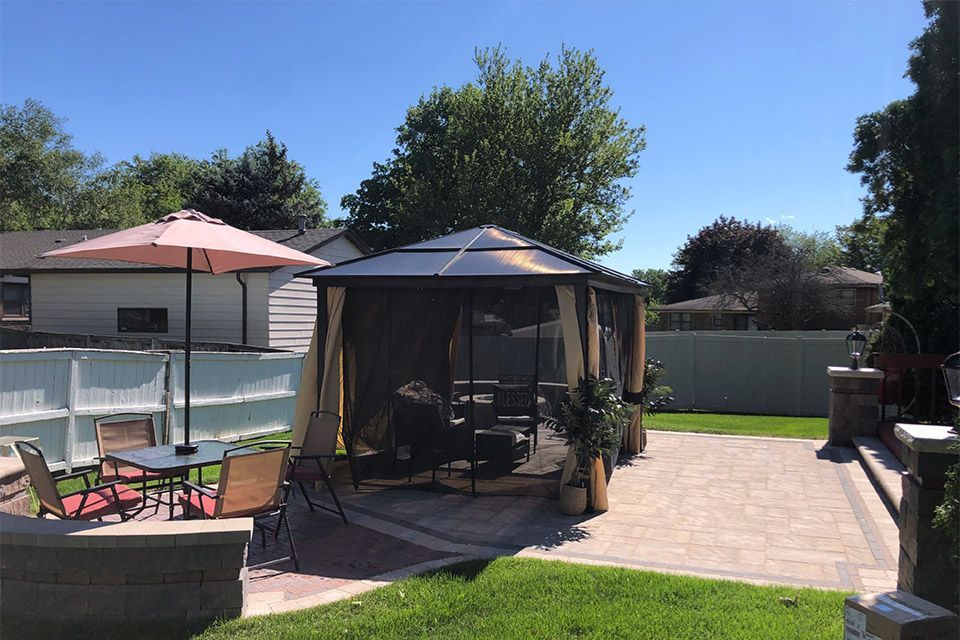 Finished outdoor living space featuring a professionally built patio with comfortable seating designed for relaxation in a residential backyard