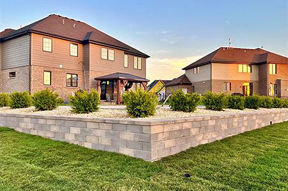 Finished hardscaping project featuring a professionally built retaining wall with clean lines and structured planting in a residential backyard