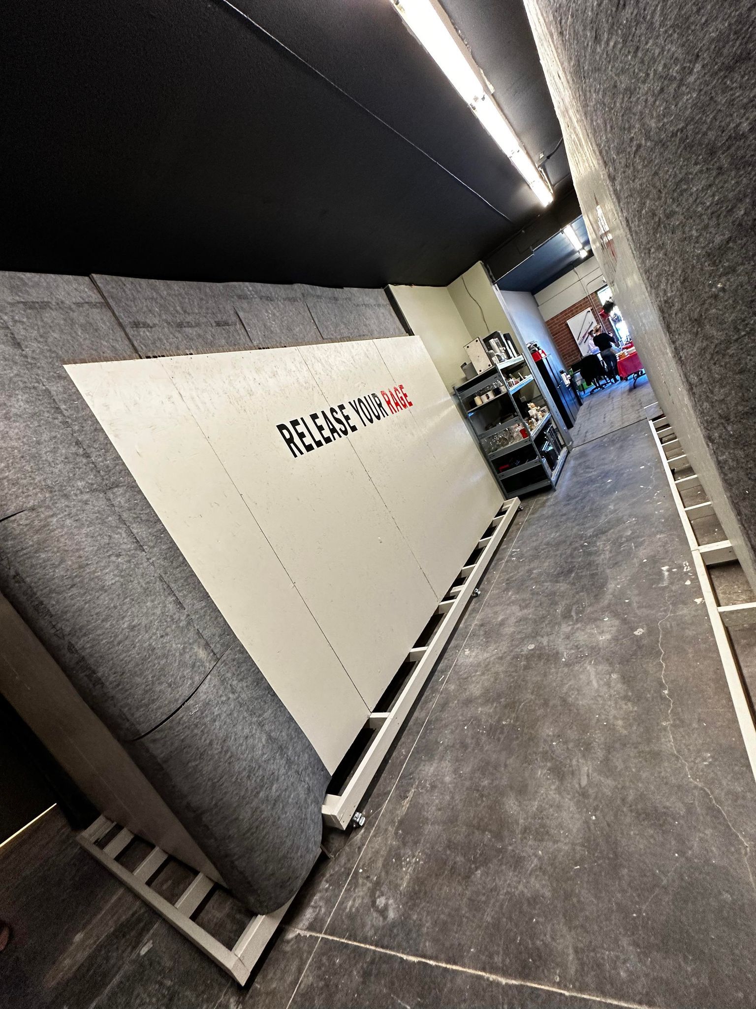 A room with a large white wall and a few shelves