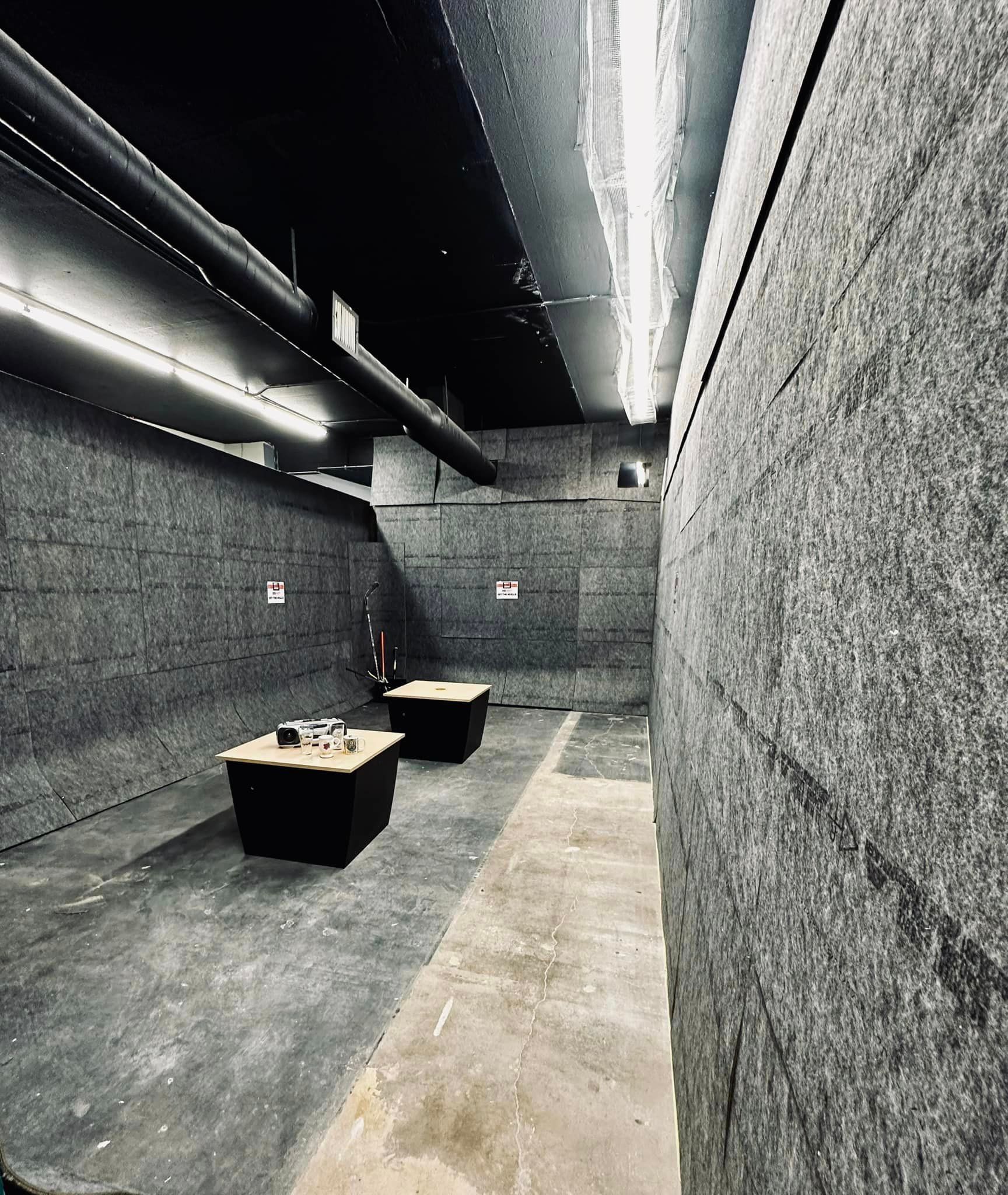 A black and white photo of a room with two tables in it.