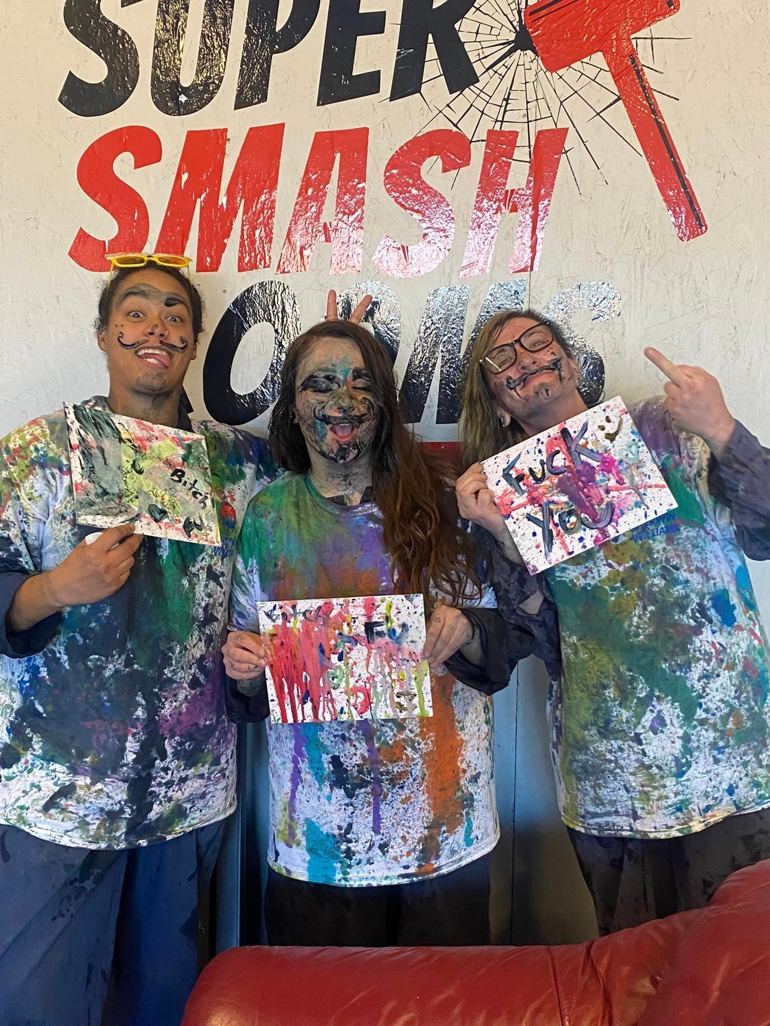 Three people are standing next to each other with paint on their faces.