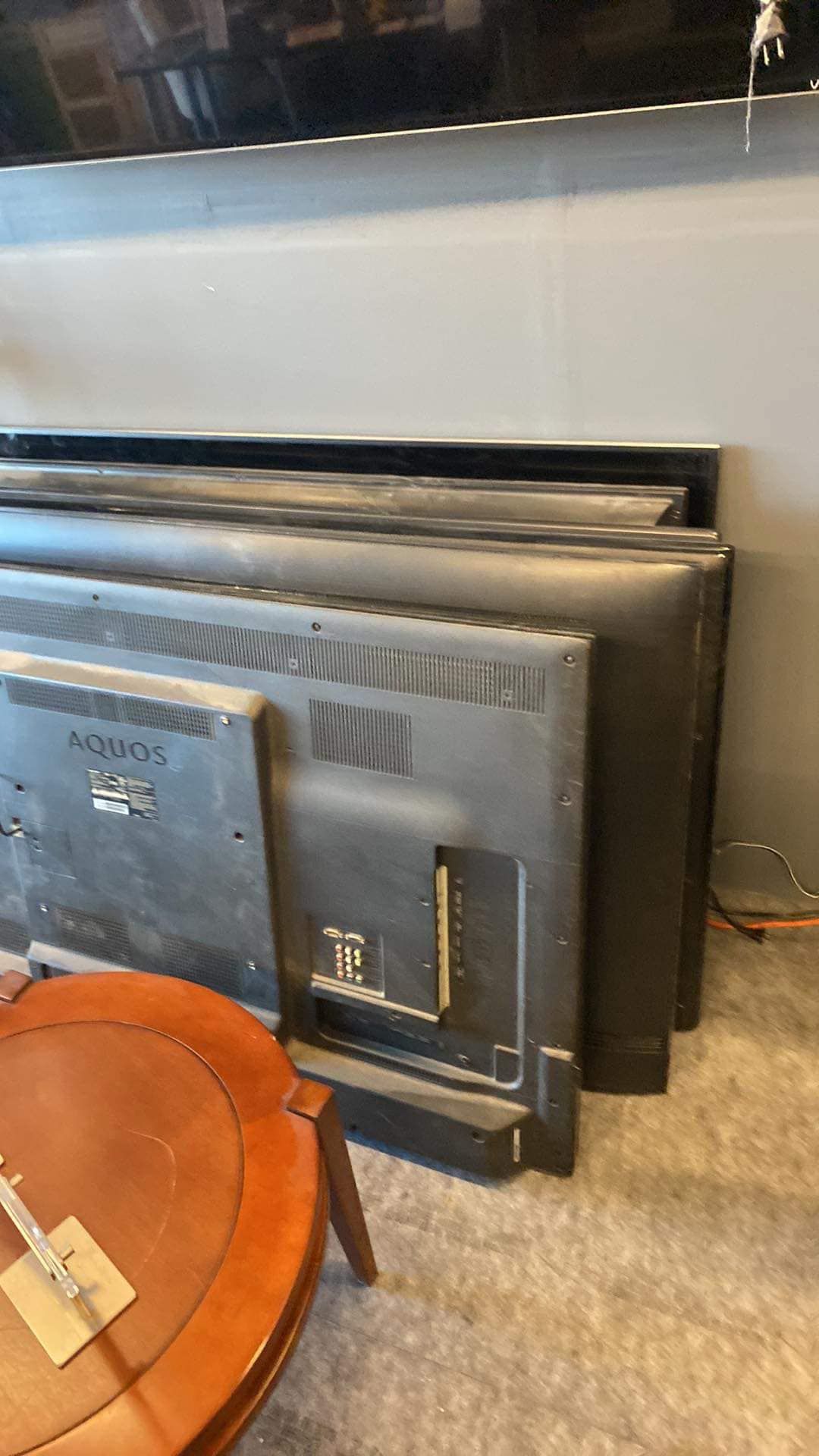 A bunch of televisions are stacked on top of each other on the floor.