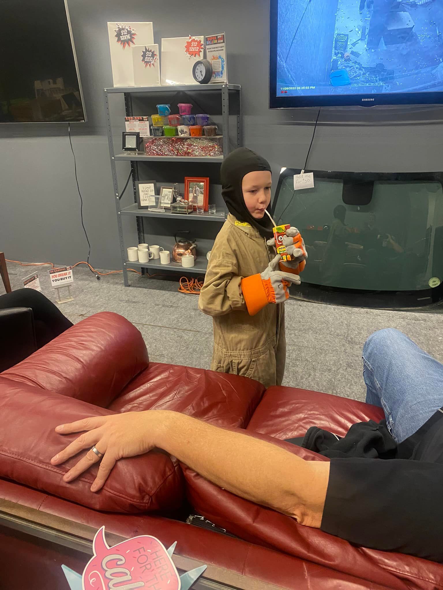 A little boy is standing next to a man on a couch in a living room.