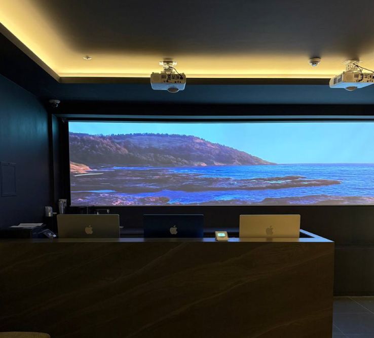 A modern hallway features textured beige booths with dark red backdrops, leading to a white door on marble flooring.