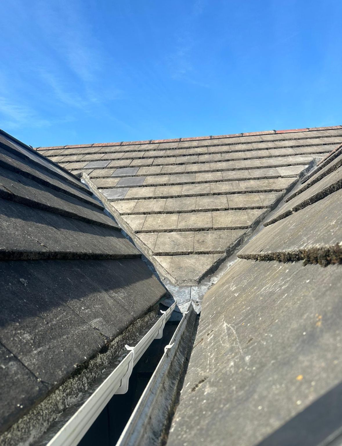 Detailed view of a tiled roof valley junction, neatly sealed where two roof planes meet at an angle.