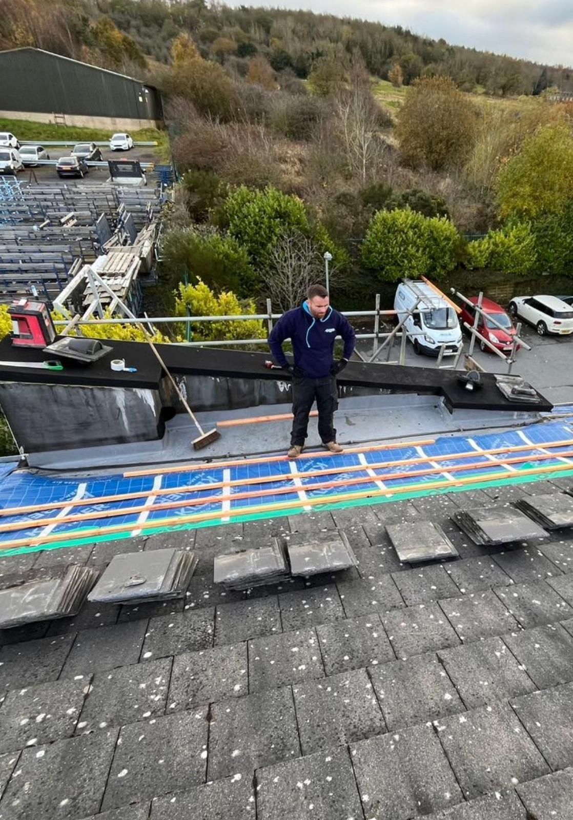 A. Armstrong Roofing employee standing over a roof