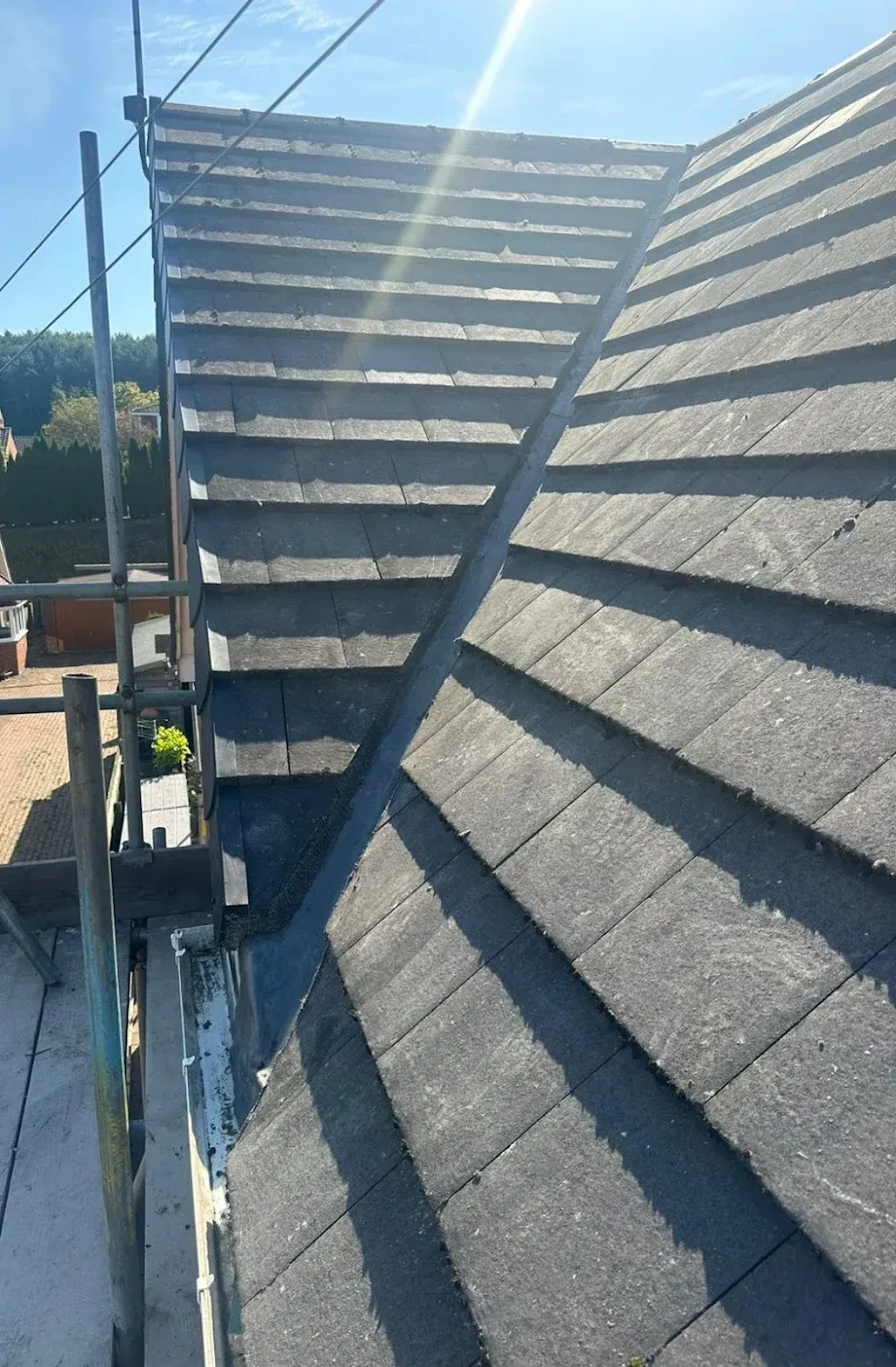 Newly coated flat roof surface with sharp, dark finish and clear lines between sections.