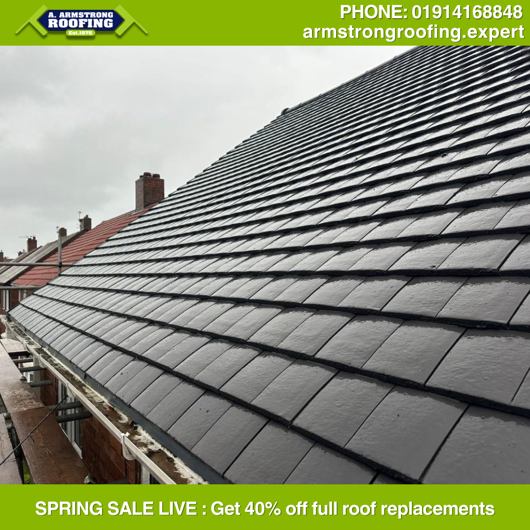 Close-up of a completed grey slate roof showing precision tiling and neat ridge work, installed by Armstrong Roofing.