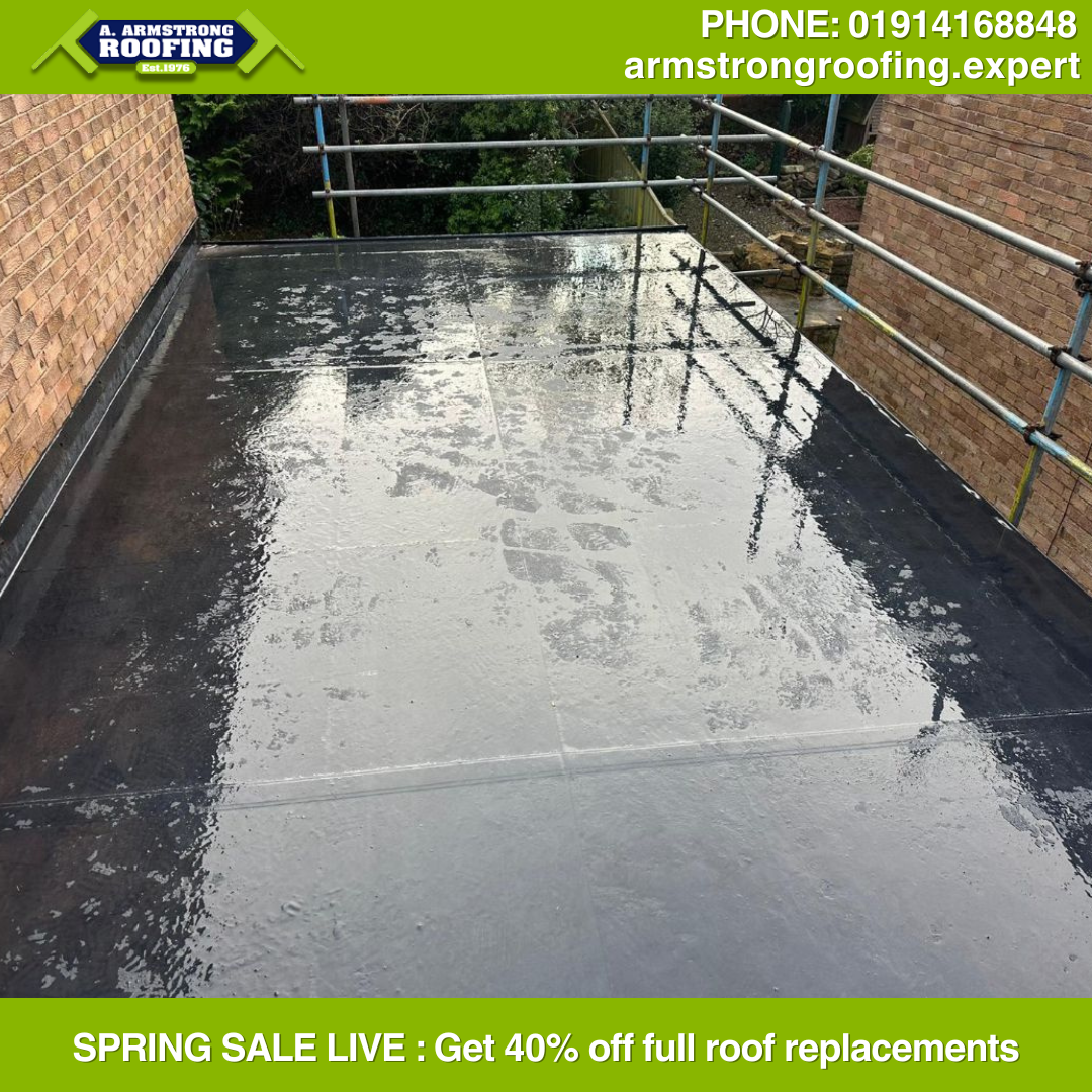 Completed flat roof installation with clean finish beside brick wall