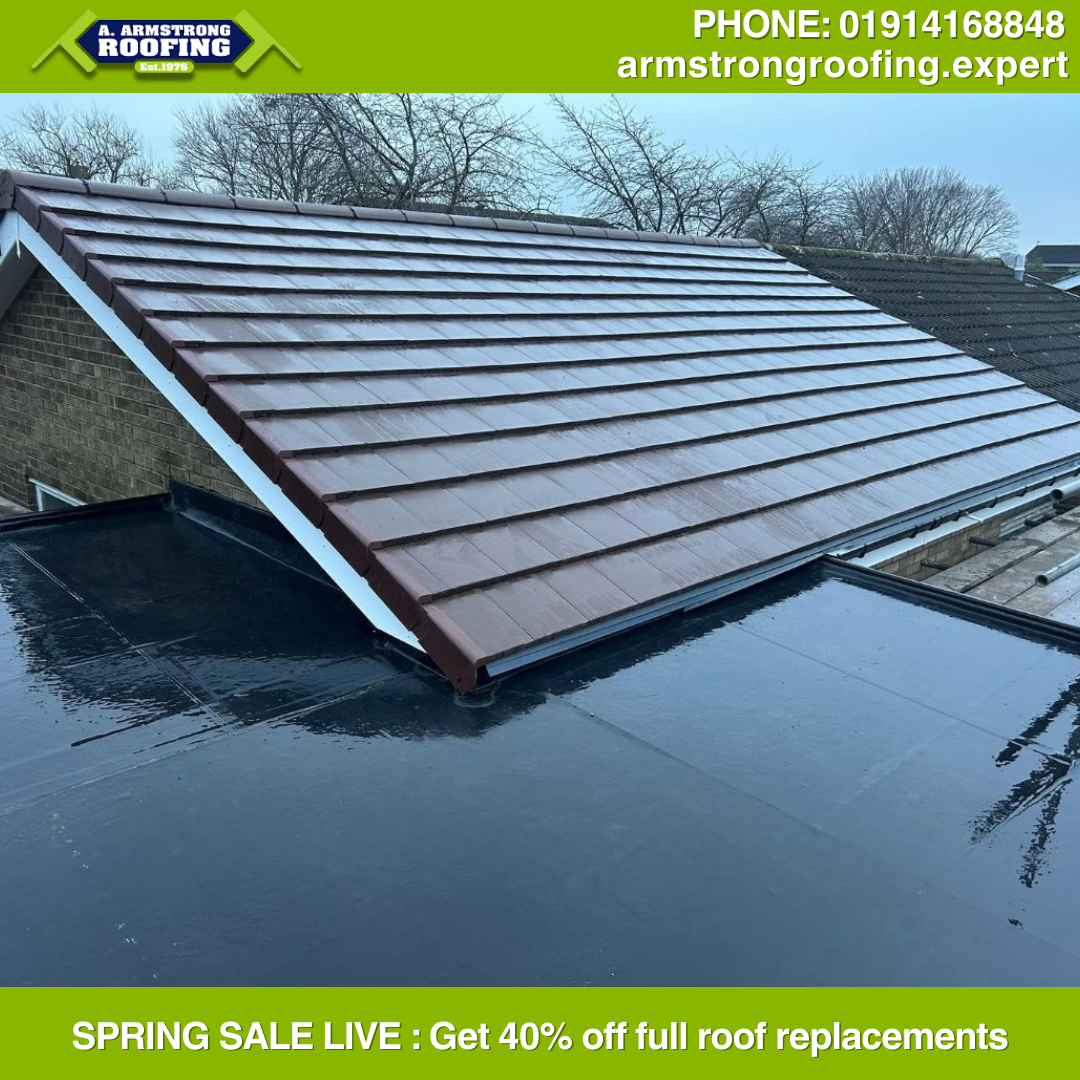 Newly tiled pitched roof above a black flat roof section in residential area